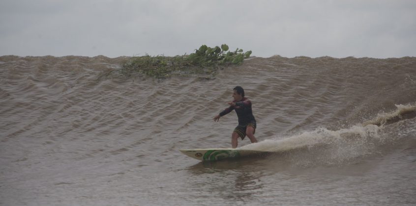 E até que enfim, depois de tanto tempo preso na espuma, Alberto Alves alcançou o rabo da onda em Mentawai, passando por plantas e galhos, Pororoca do Rio Araguari (AP). Foto: Toninho Jr..