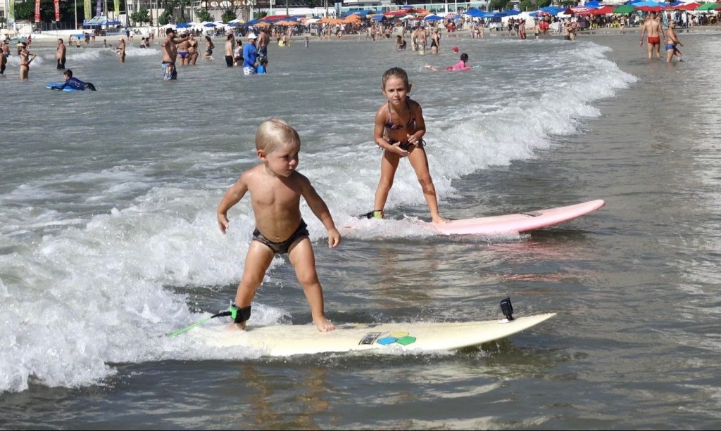 João Vitor, 2, e Maria Clara, 5, começam no surfe desde cedo no litoral paulista.