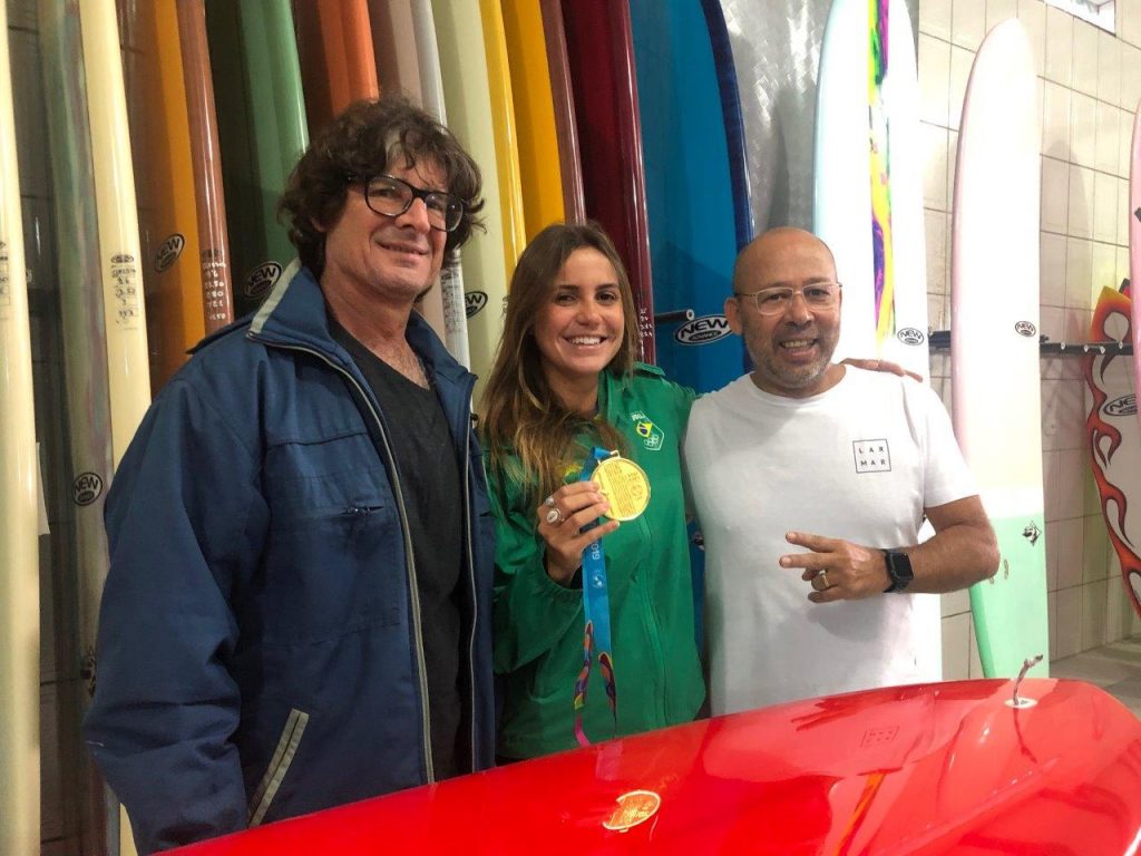Shaper Neco Carbone ao lado de Chloé Calmon e do empresário Sérgio da Silva na fábrica da New Advance em São Vicente.