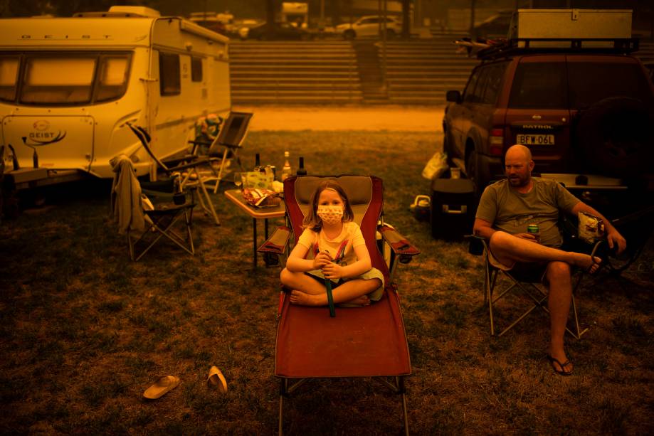 Família australiana que abandonou sua moradia devido os incêndios descansa em um campo para deslocados.