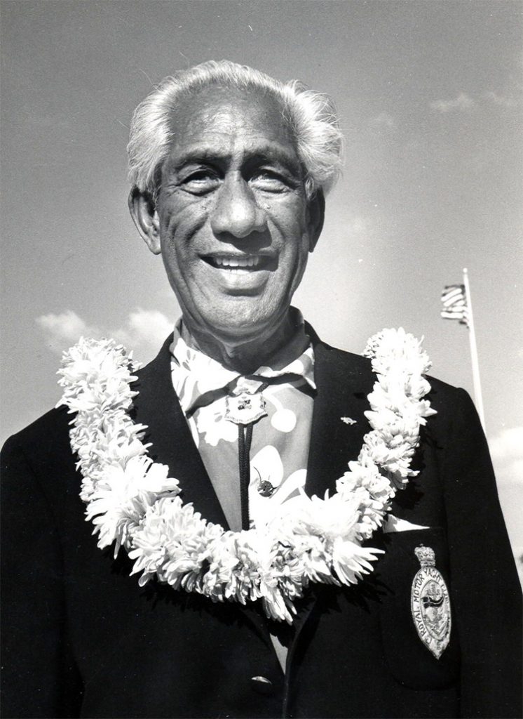 Duke usando um colar havaiano e o distintivo do Royal Motor Yacht Club.