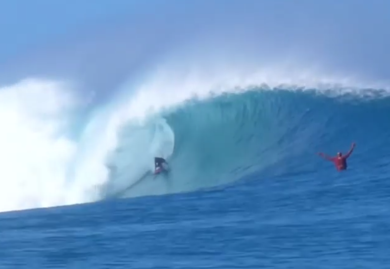 Kaiwi Berry  bota no trilho enquanto Kelly Slater comemora do canal em outer reef de Oahu.