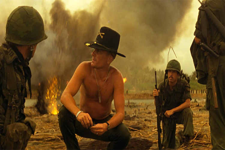 Robert Duvall (sem camisa) é militar surfista em Apocalypse Now.