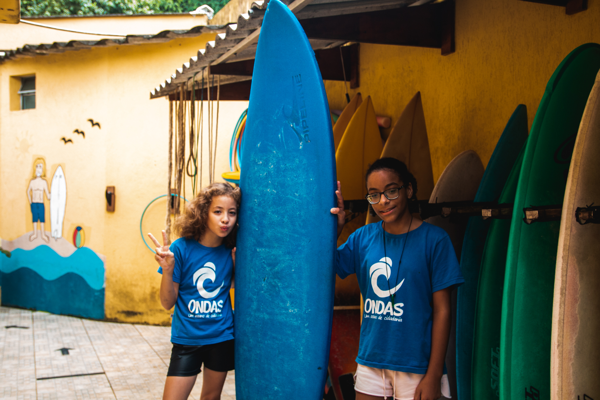 Meninos e meninas aprender a surfar com Jojó Olivença.