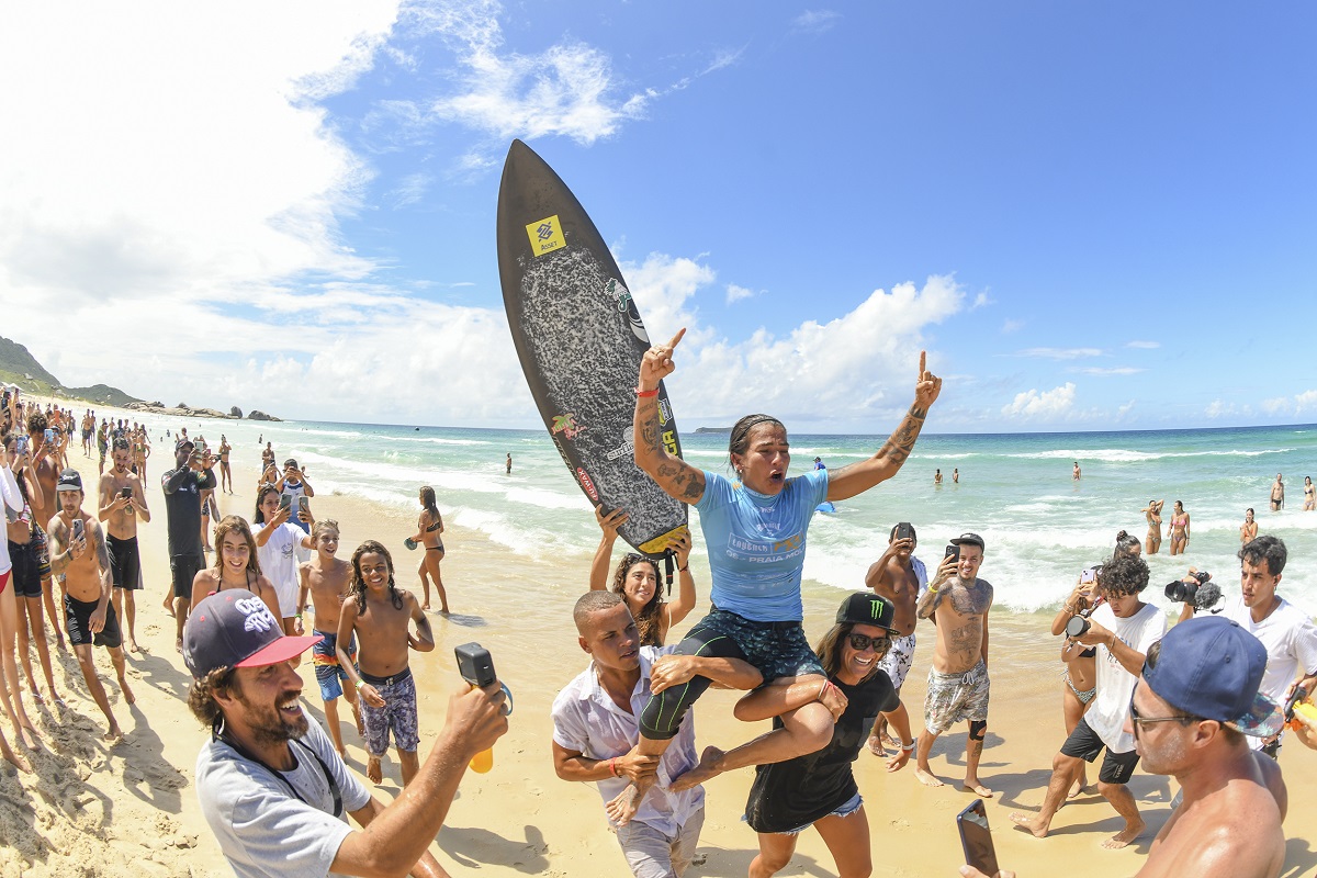 Silvana Lima é carregada pelos surfistas Douglas Lima e Dominic Barona.
